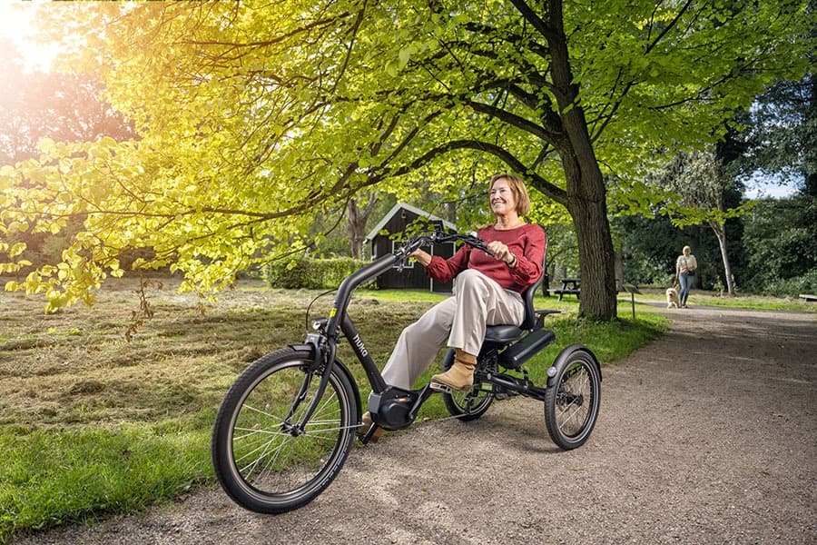 Huka Cortes driewielfiets sfeerbeeld vrouw fietsend door het bos