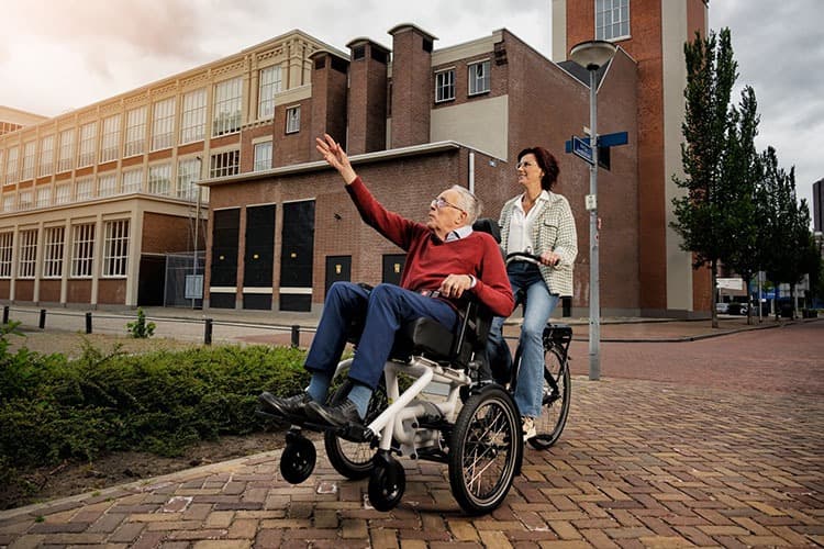 Huka Diaz rolstoelfiets met afneembare rolstoel sfeerbeeld oudere op fiets
