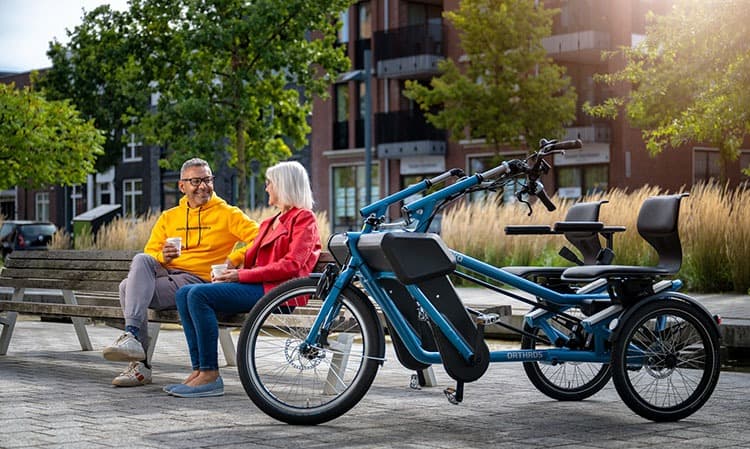 Huka Orthros duofiets zilver zijaanzicht sfeerbeeld kop koffie op een bankje