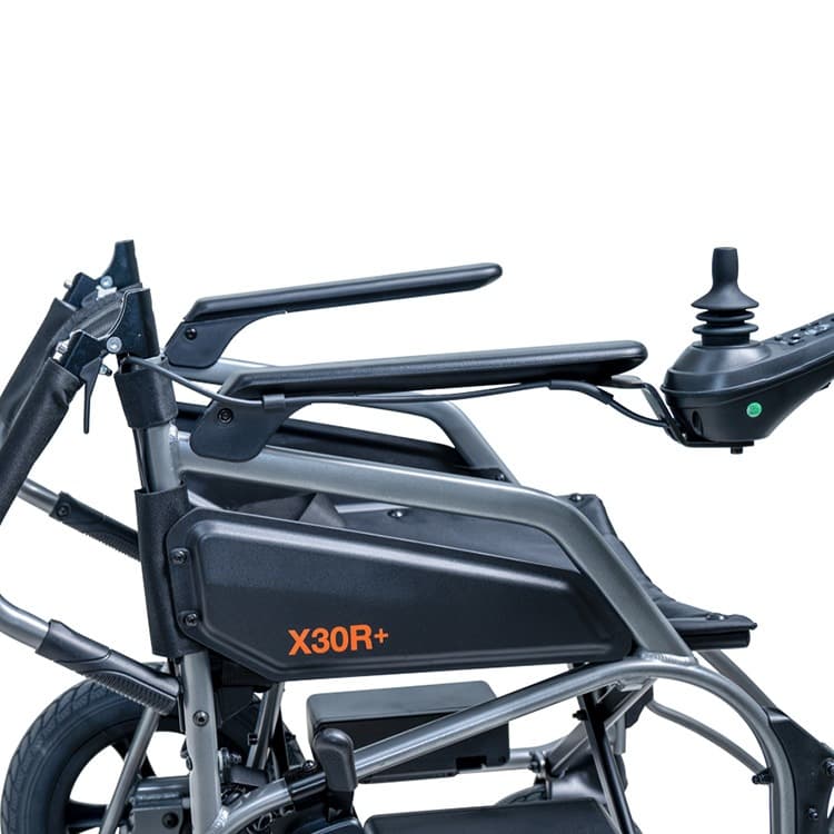 Excel X30R+ elektrische rolstoel met voetsteunen, heupgordel en joystick bediening en zwart frame met lichtgrijze bekleding en stevige zijpanelen rugleuning achterover geklapt