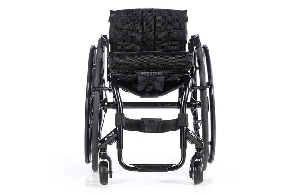 Quickie Nitrium maatwerk rolstoel zonder handvatten met voetsteun in het midden om zelf te hoepelen vooraanzicht centrale voetsteun, dik zitkussen en schuine wielen om zelf te hoepelen