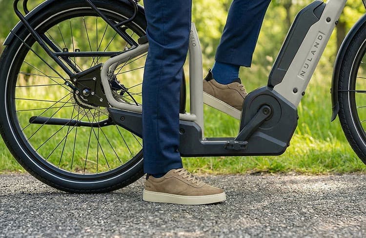 Nijland Suelo lage instap fiets turquoise met zwart twee wielen opstappen en stil staan met de voeten aan de grond