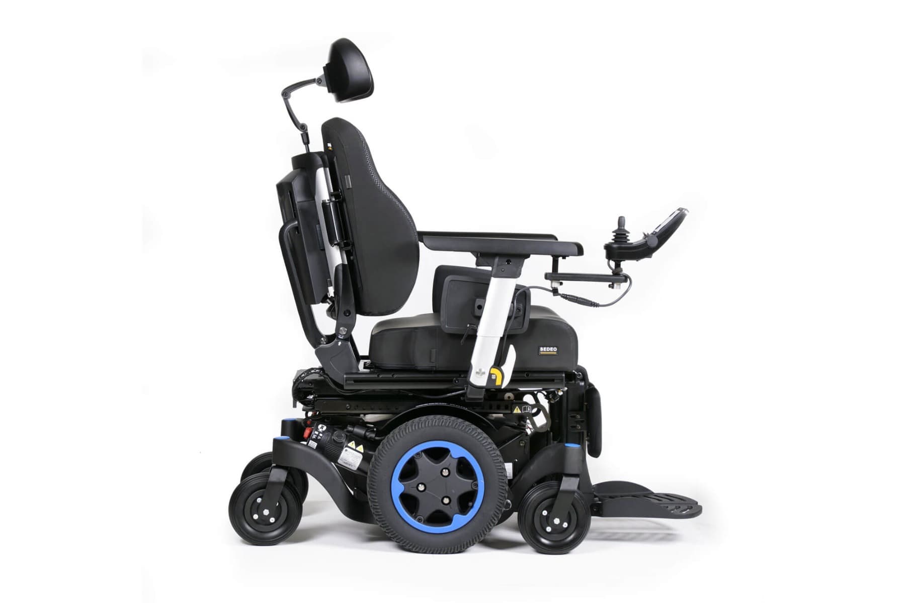 Quickie Q300 Mini elektrische rolstoel maatwerk met grote voetsteunen, ergnomische zitting en hoofdsteun en joystick bediening beeld met midwielmotor en sedeo zitting zijaanzicht middenmotor, dik zitkussen en stevige rugleuning