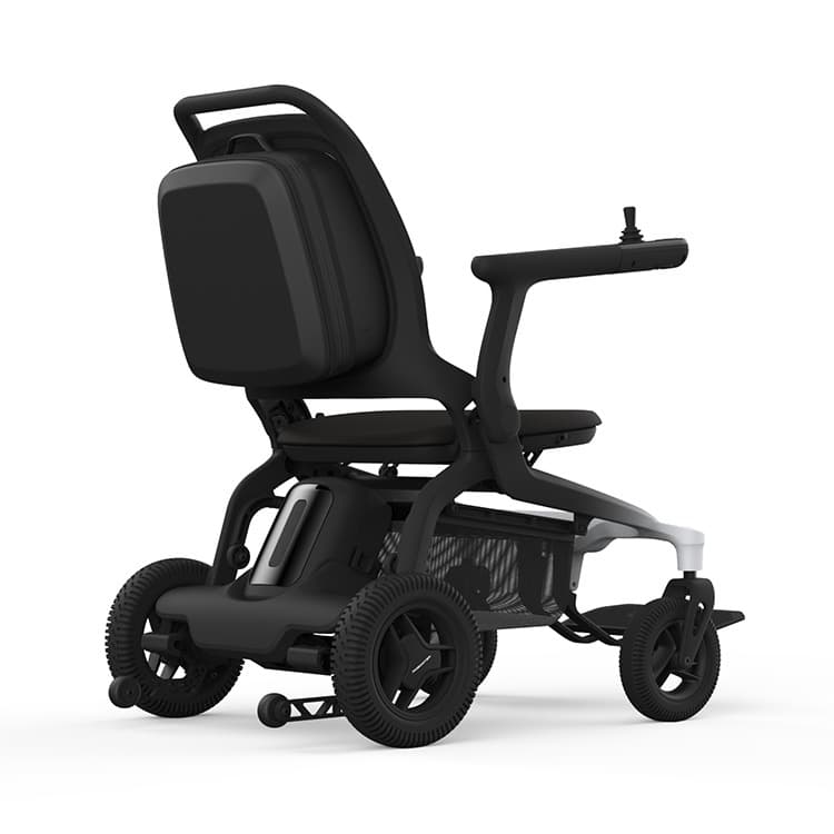 Revamed Robooter E80 Elektrische rolstoel zwarte bekleding en frame met verloop naar wit vooraan het frame. Voetensteun in het midden van de rolstoel en bestuuringsjoystick aan het uiteinde van de armleuning. Koffer achterop de rugleuning en anti-kiepwiel