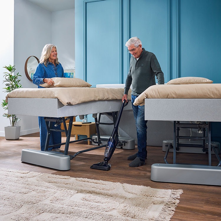 Deron Timeless Deluxe tweepersoons hoog-laagbed lichtgrijs verstelbare lattenbodem sfeerbeeld opgemaakt bed met hoofdbord (niet standaard inbegrepen) beide kanten van het tweepersoonsbed uit elkaar gehaald en omhoog gezet zodat je makkelijk onder het bed